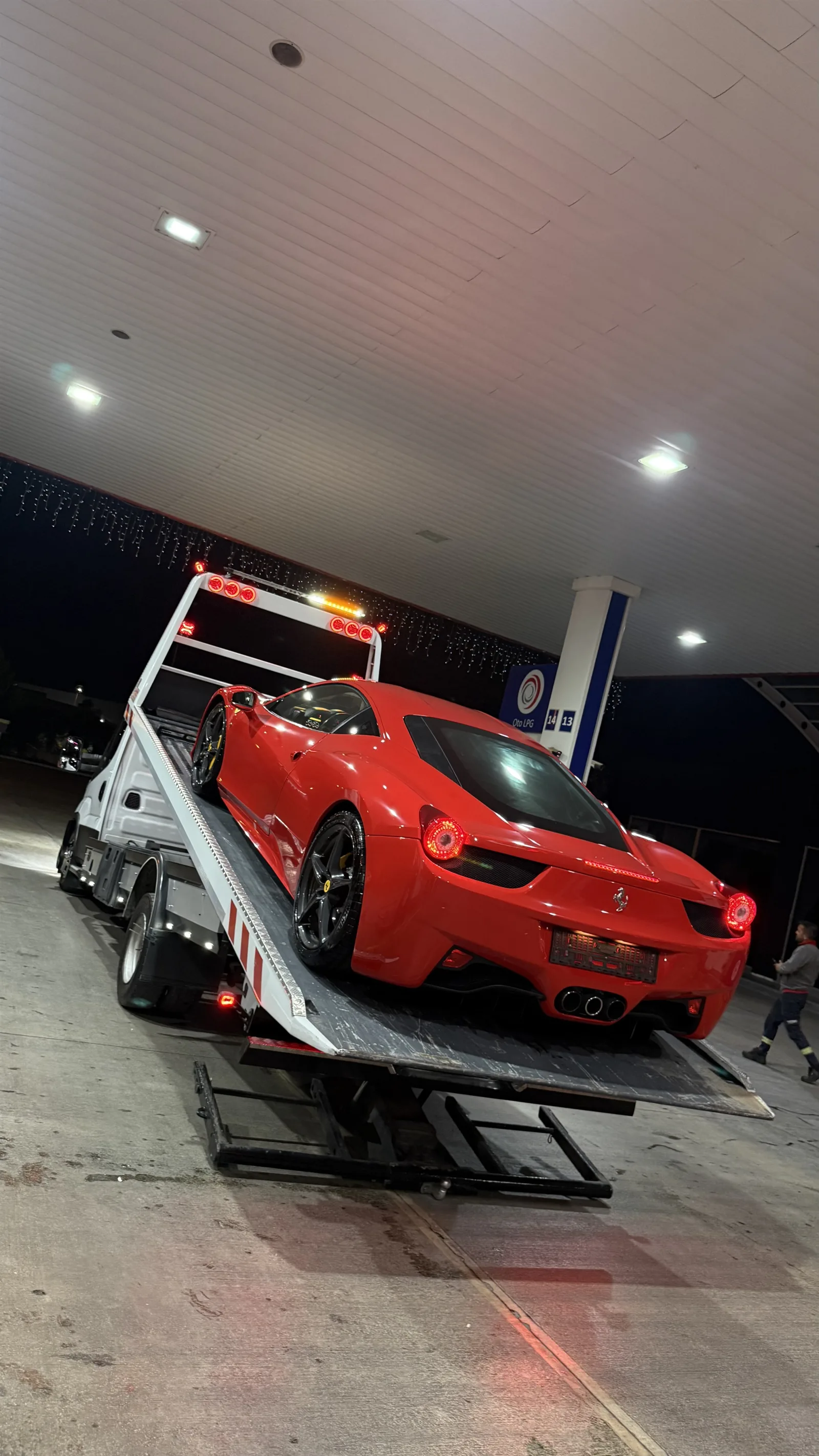Gece aydınlatmasında çekici platformuna yüklenmiş kırmızı spor otomobil